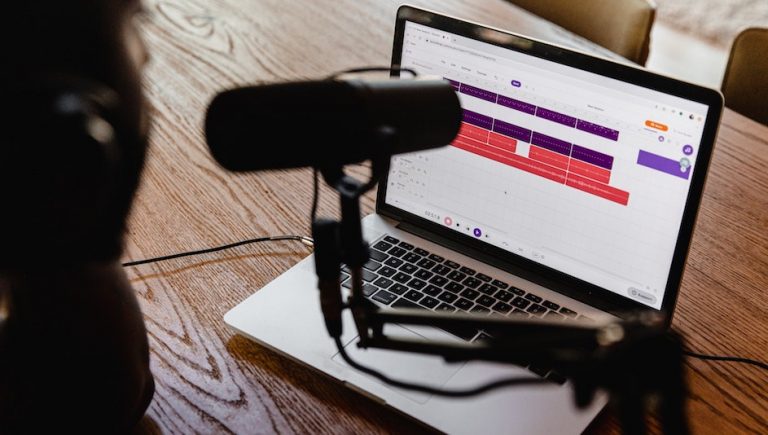 A woman speaks into a microphone as she records a podcast. Photo by Soundtrap, from Unsplash