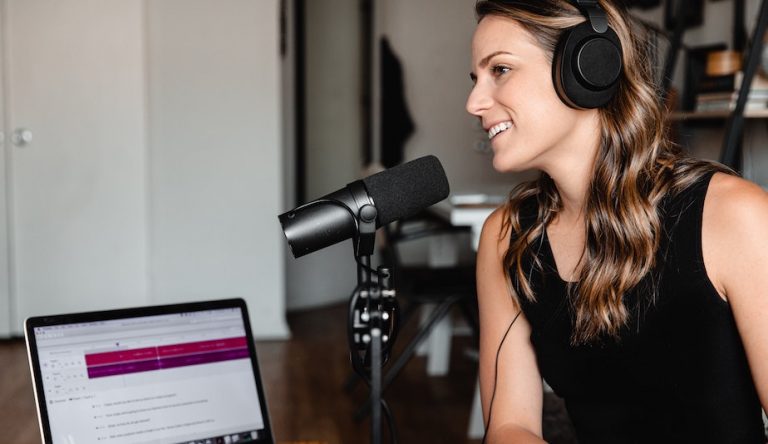 A woman speaks into a microphone attached to a laptop. Photo by Soundtrap from Unsplash