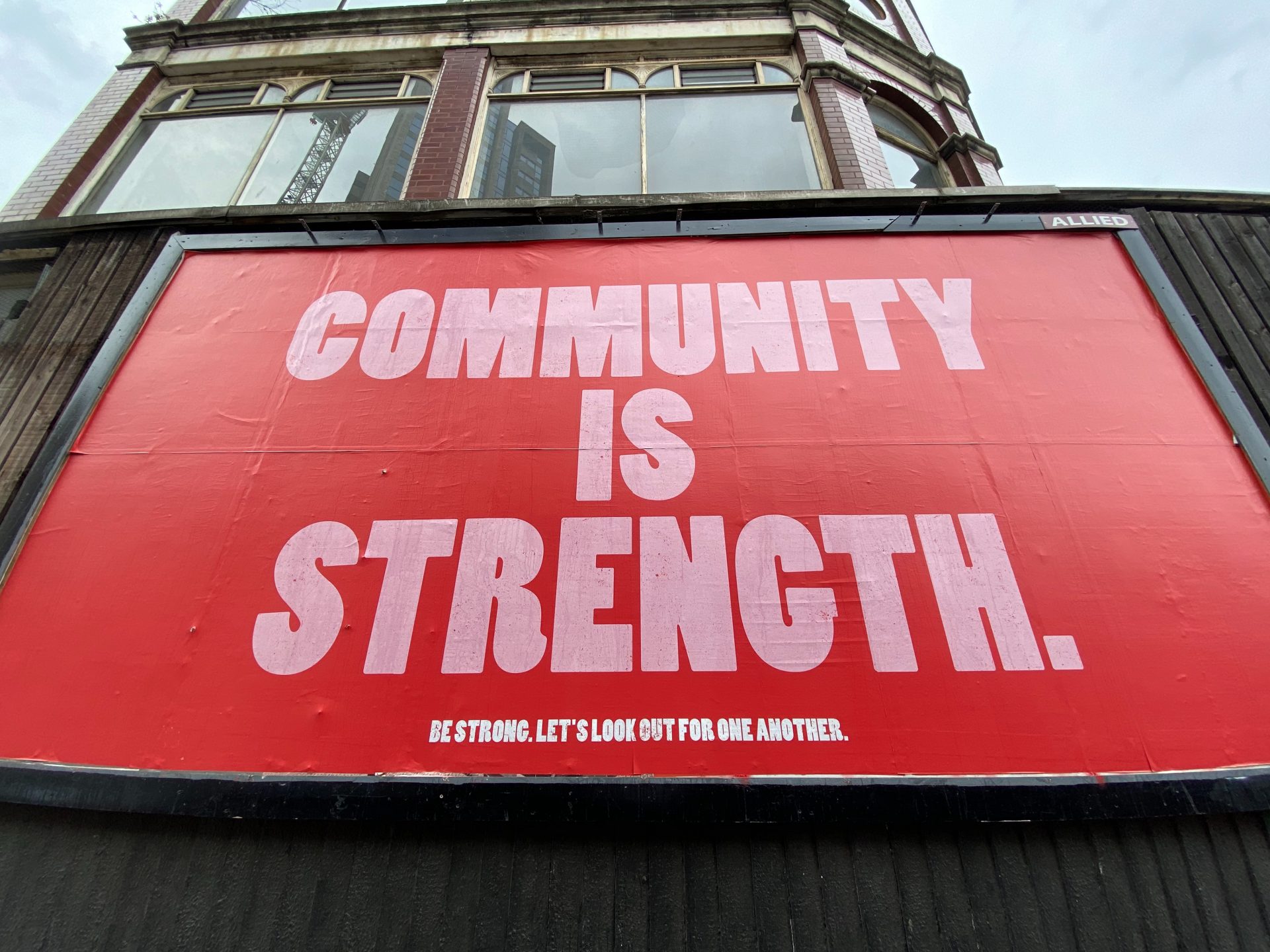 A billboard reading 'Community is strength'