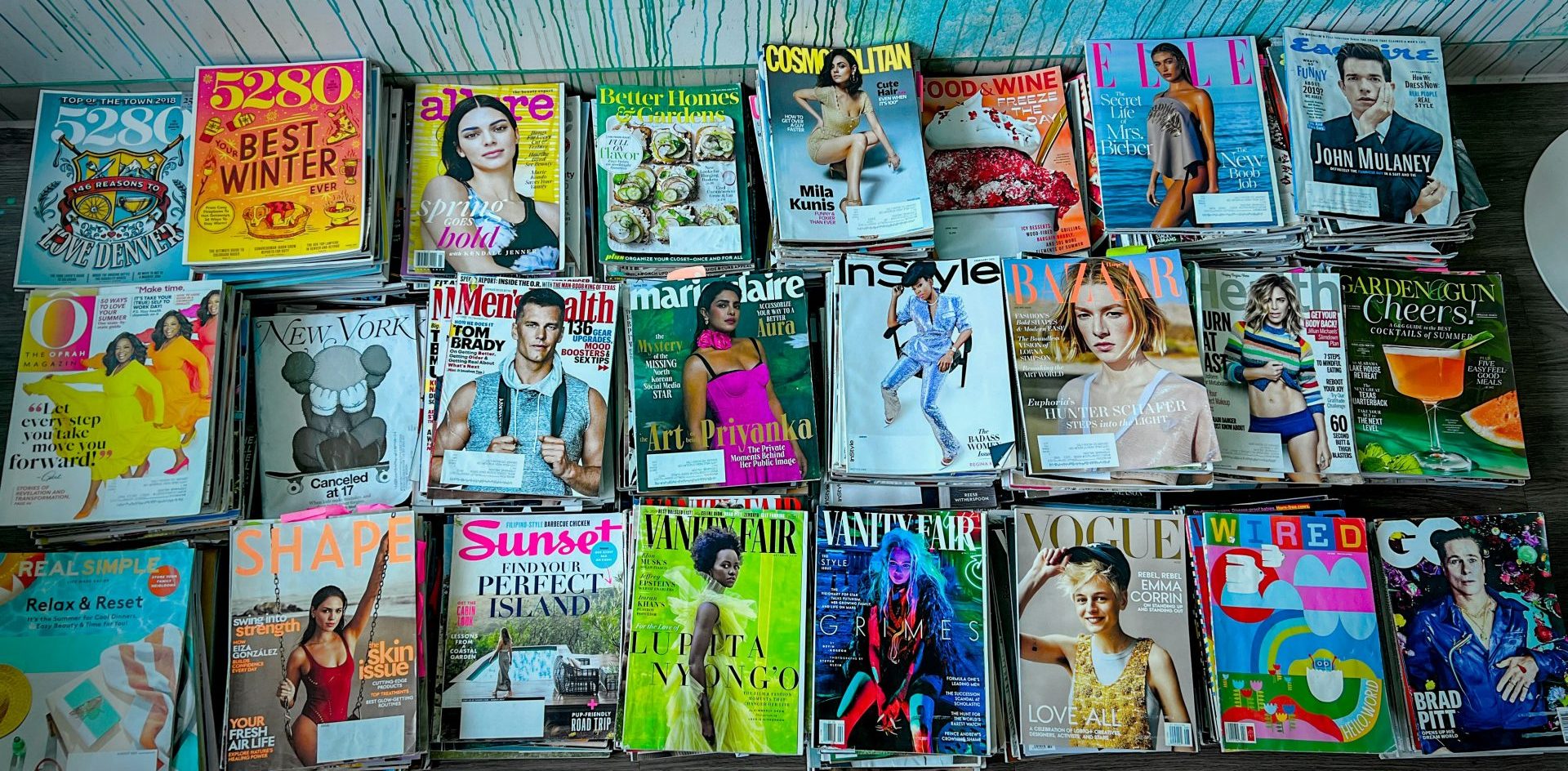 A collection of stacked magazines. The average US consumer has 8 subscriptions and is increasingly aware of their subs spending. Photo by Steph Wilson